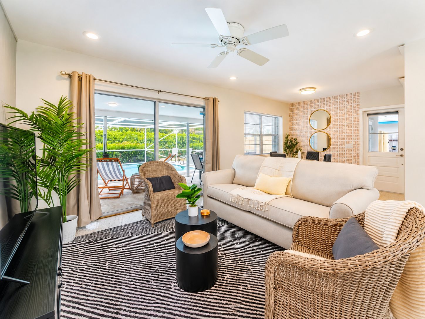 A modern living room with a sofa, chairs, a coffee table, and a television.
