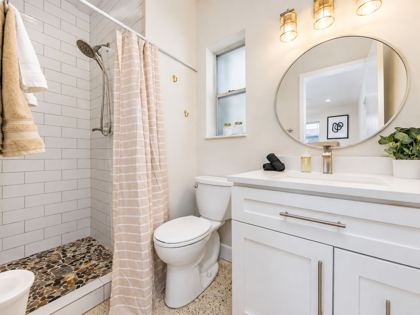 A bathroom with a shower, toilet, and sink.