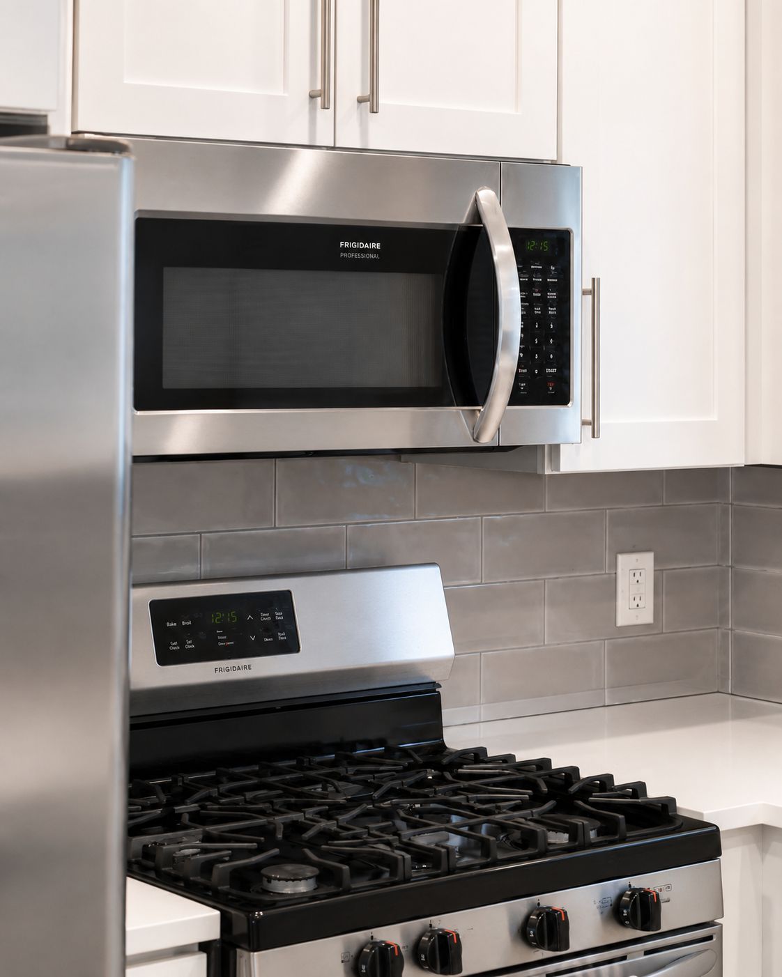 A kitchen with stainless steel appliances, including a microwave, oven, and gas stove.