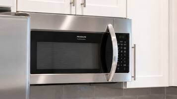 A kitchen with stainless steel appliances, including a microwave, oven, and gas stove.