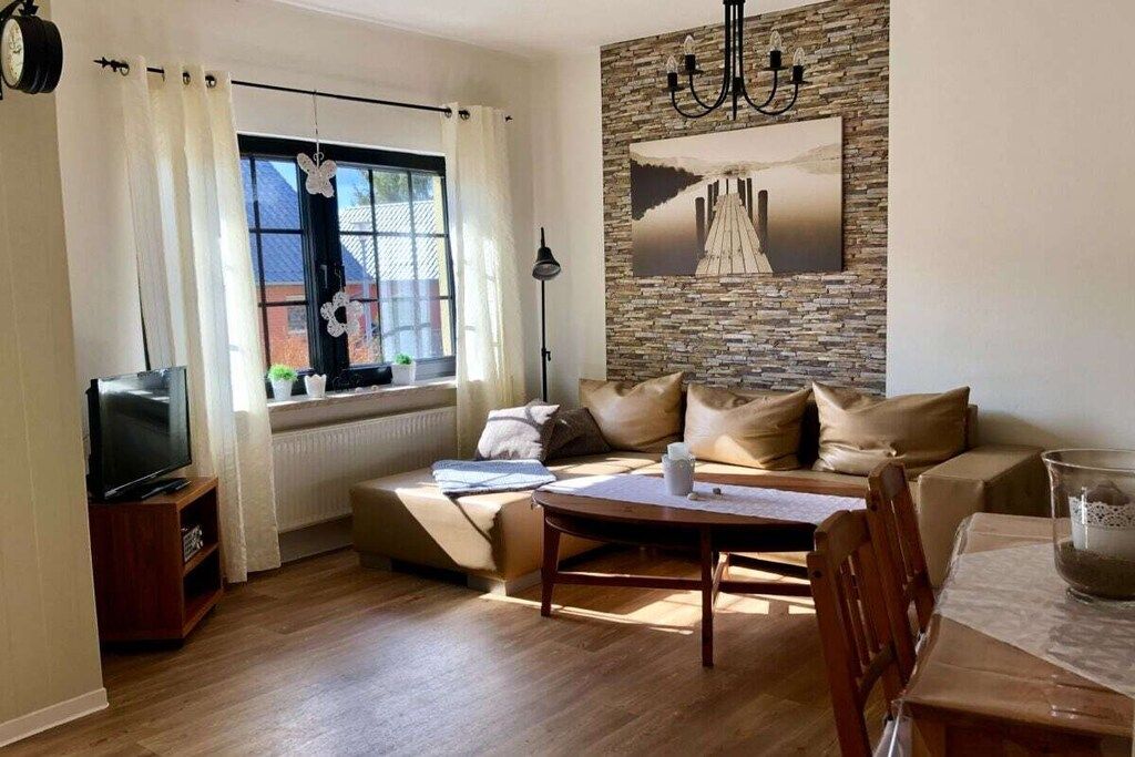 A living room with a sofa, a coffee table, a TV, and a fireplace.