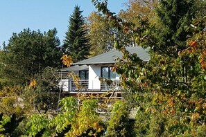 Een modern gebouw met een plat dak, omgeven door weelderige begroeiing en bomen.