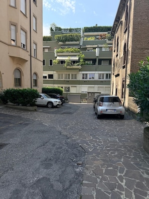 Eine schmale Straße mit parkenden Autos und Häusern an beiden Seiten.