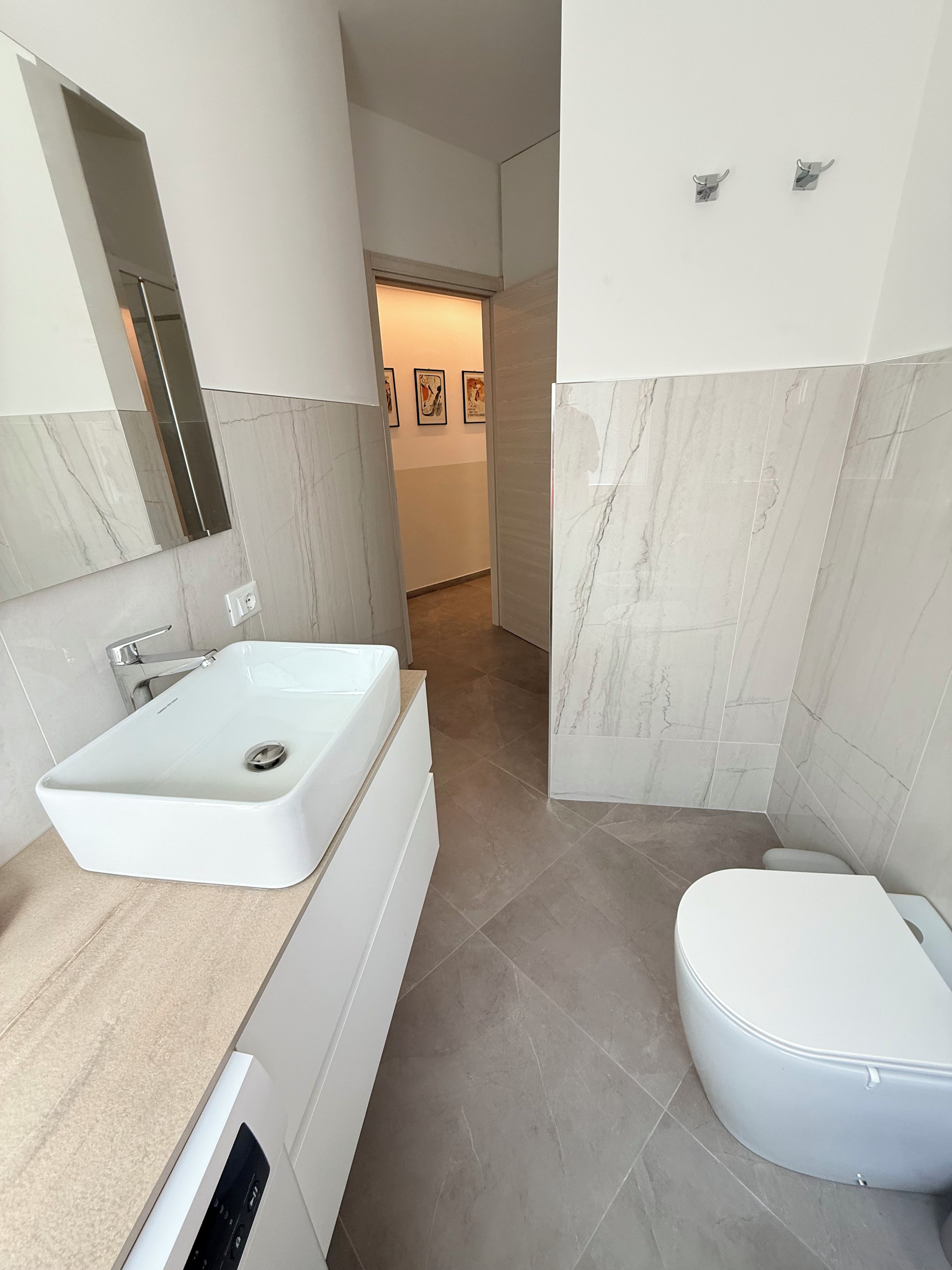 Un bagno moderno con un ampio lavabo rettangolare, un WC e una zona doccia.