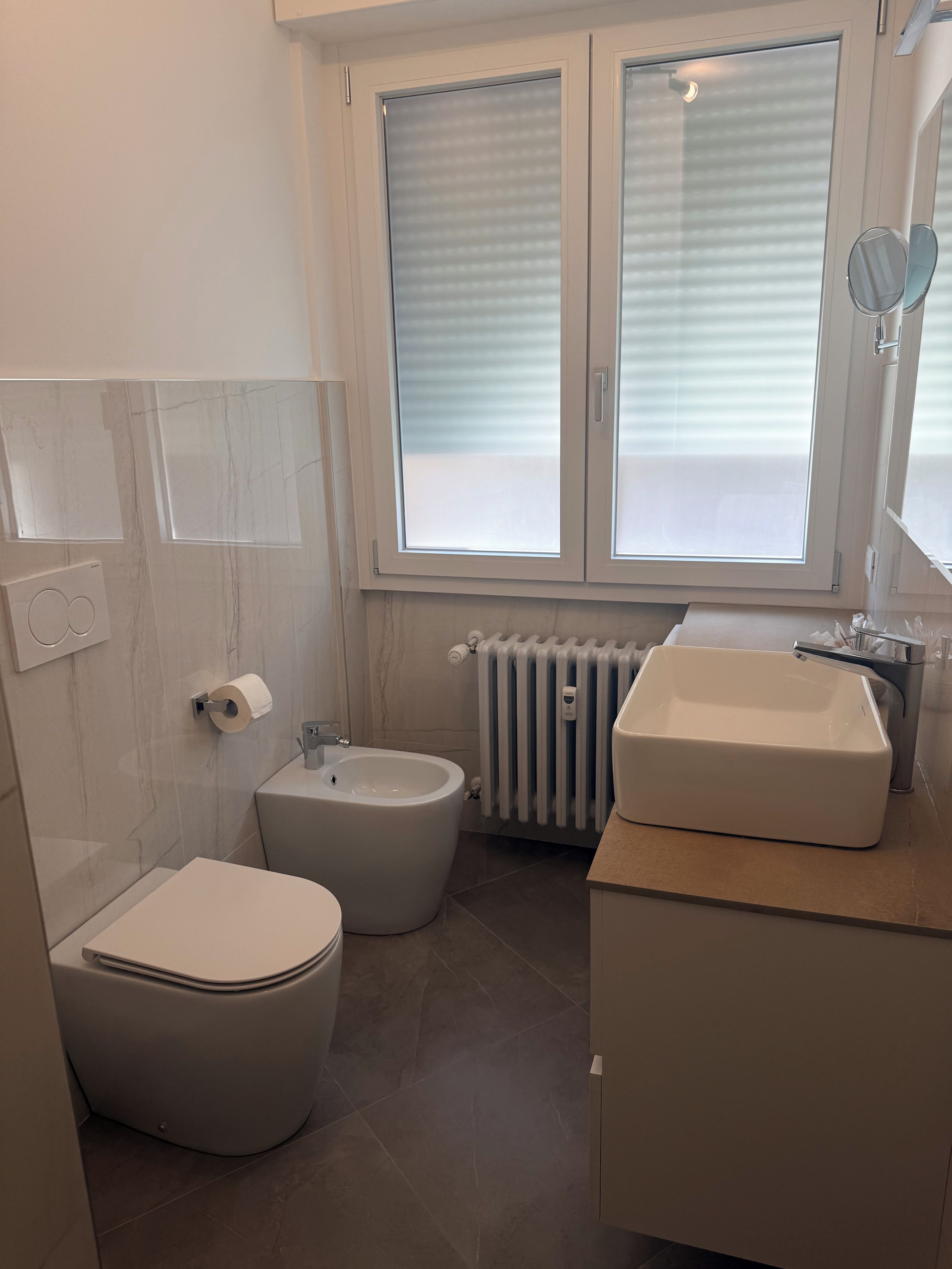 Ein Badezimmer mit Toilette, Bidet und Waschbecken.