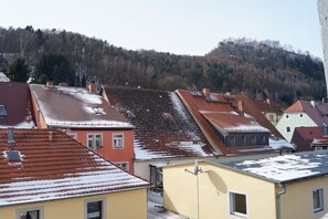 A residential area with terraced houses, a hill in the background, and a clear sky. - Holiday apartment with 1 bedroom (Königstein)