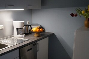 A kitchen with a coffee maker, toaster, and fruit basket on the counter. - Holiday apartment with 1 bedroom (Königstein)