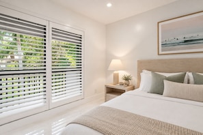 A bedroom with a bed, bedside table, lamp, and a framed picture on the wall. - Renovated PGA National Home by Guaranteed Rental (Palm Beach Gardens)