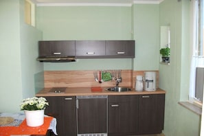 A compact kitchen with a sink, a coffee maker, and a dish rack. - Holiday apartment with 1 bedroom (Dresden OT Borthen)