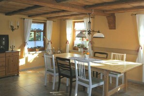 Ein Essbereich mit einem Holztisch, weißen Stühlen und einer Kronleuchter.