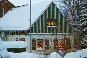 A snow-covered building with a green facade and multiple windows. - Finsterbusch's little house (Oelsnitz\/Vogtland)
