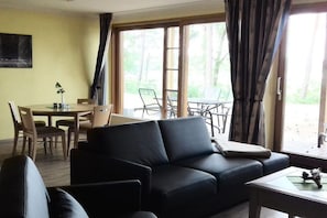 Una sala de estar con un sofá, una mesa de centro y un comedor con sillas y una mesa.