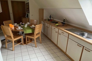 A compact kitchen with a dining table, chairs, and a sink. - Crane in Röbel/Müritz (Röbel\/Müritz)