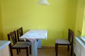A dining area with a table, four chairs, and a ceiling light fixture. - Holiday apartment with 1 bedroom (Zehdenick)