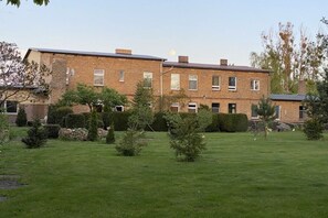 A two-story brick building with a grassy lawn and small trees. - Holiday apartment with 1 bedroom (Zehdenick)