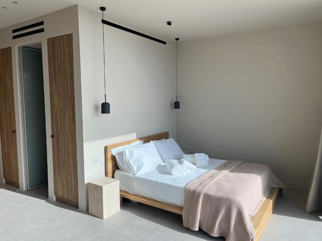 Une chambre à coucher moderne avec un lit, des tables de chevet et des lampes suspendues.