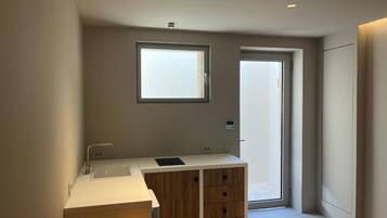 A modern bathroom with a large window, a built-in sink, and a wooden cabinet.