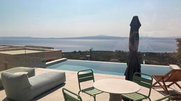 Zona junto a la piscina con vistas al mar y a las montañas.