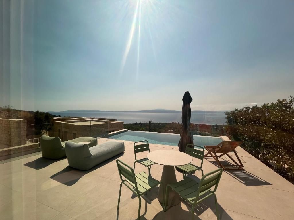 A rooftop terrace with a pool, outdoor furniture, and a view of the sea.