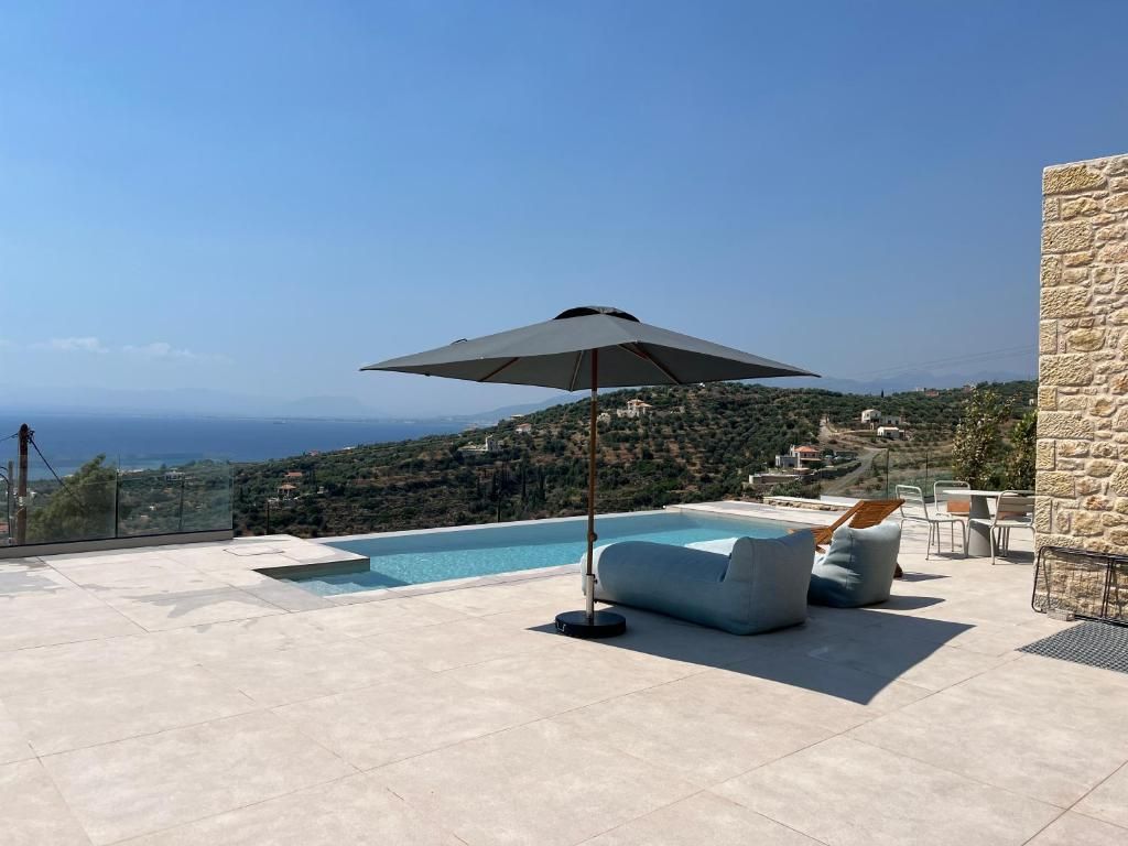 Une terrasse sur le toit avec une piscine, une chaise longue et un parasol.