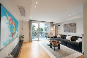 A modern living room with a sofa, coffee table, and artwork on the walls. - Book&Bed-The Bund People's Square 1 (Shanghai)