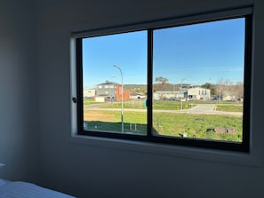 Ein Zimmer mit großem Fenster mit Blick auf einen Parkplatz und Gebäude.