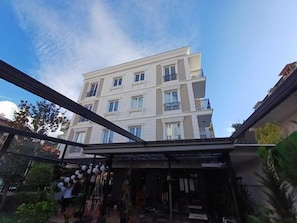 A multi-story building with balconies, a clear sky, and a glass structure in the foreground. - Oxygen Boutique Hotel Tirana (Tirana)