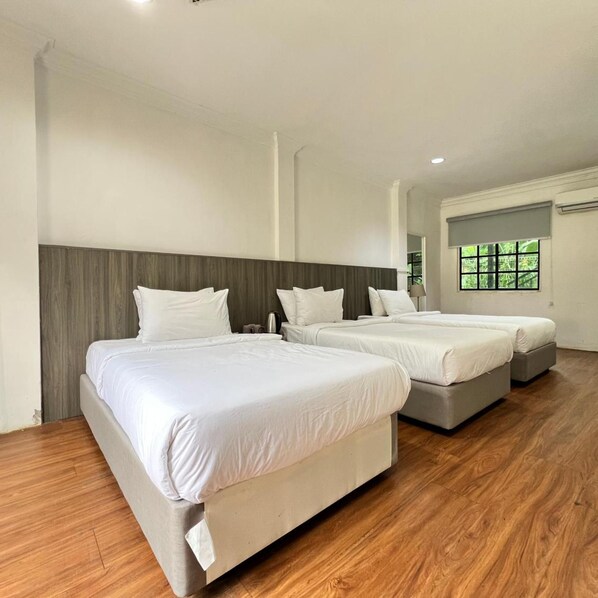 A hotel room with two beds, a wooden floor, and a window with a view. - Lilla Hilltop Retreats (Janda Baik)