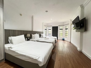 Una camera d'albergo con due letti, una TV a schermo piatto e ampie finestre.