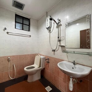 Un bagno con un WC, una cabina doccia e un lavandino.