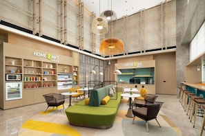 A modern interior with a seating area, a kitchenette, and a coffee station. - Home2 Suites by Hilton Liaocheng Dongchang (Liaocheng)