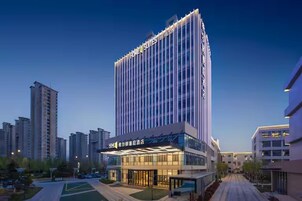 Un hotel moderno con una fachada de vidrio llamativa y un letrero que indica que es un hotel Hilton.