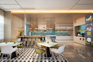 Un interior de restaurante moderno con una zona de bar, mesas de comedor con sillas y un suelo estampado.