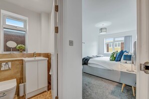 Et moderne badeværelse med toilet, vask og spejl.