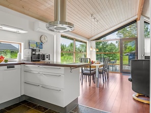 Una cocina moderna con una isla central, electrodomésticos integrados y ventanas amplias.