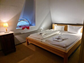 A hotel room with a bed, bedside table, lamp, and a window with a view. - Holiday Home in Nieblum With Swimming Pool (Nieblum)