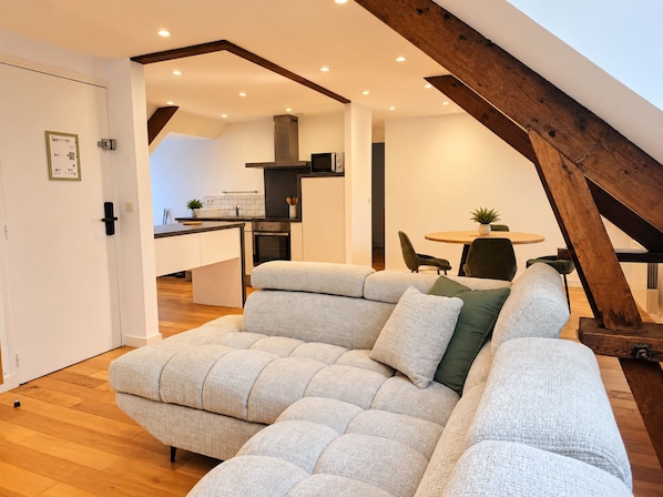 A modern loft with a loft bed, a dining area, and a kitchen.