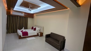 Une chambre moderne avec un lit, une table de chevet, un canapé et une lucarne.