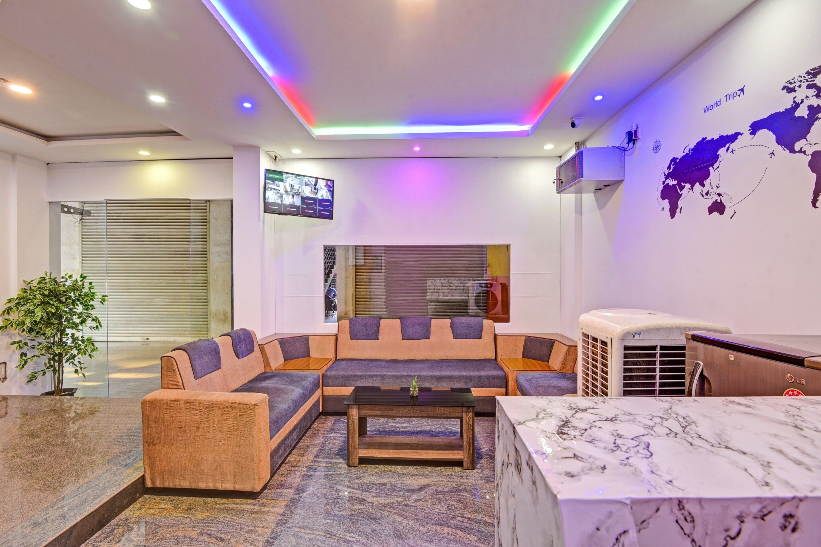 A modern lobby with a sectional sofa, a marble coffee table, and a world map on the wall.