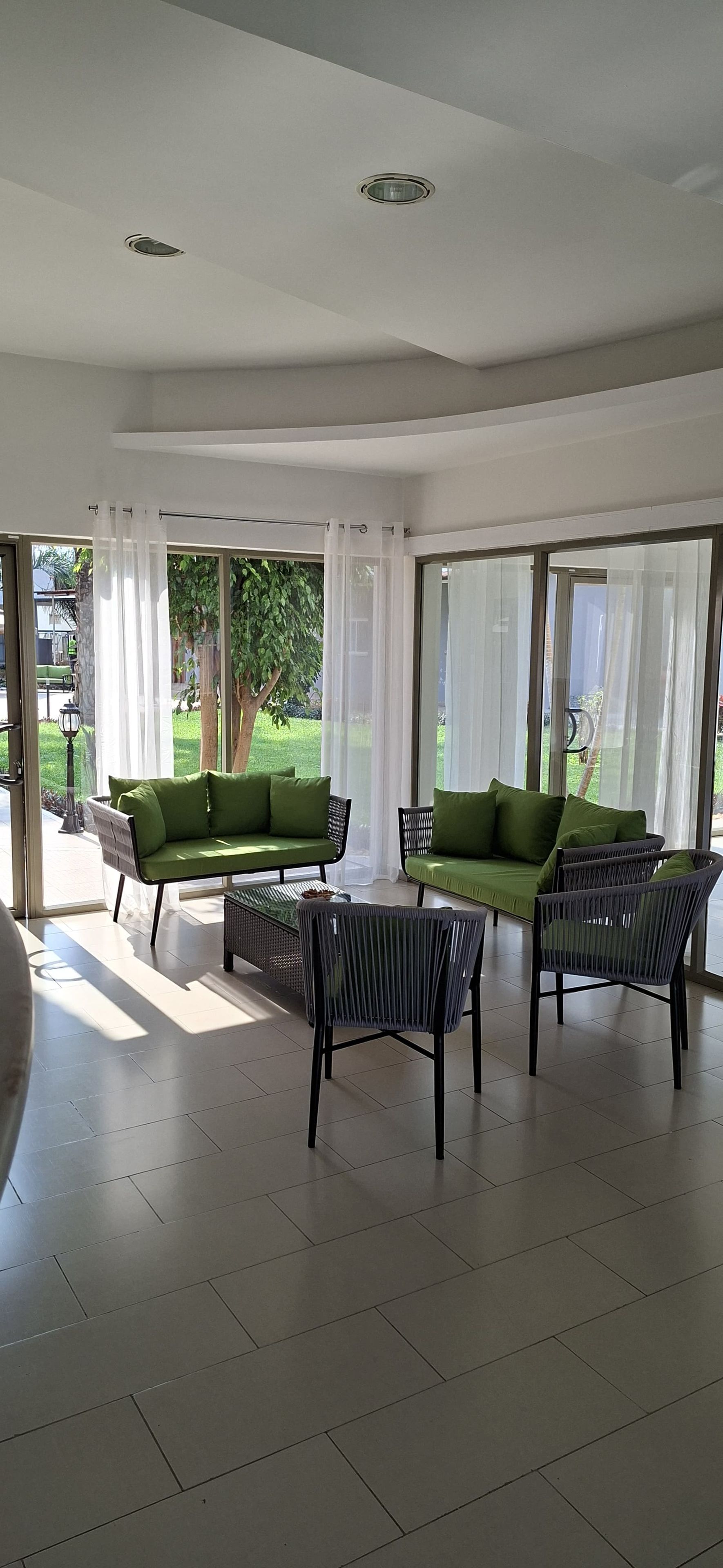 A spacious indoor area with a sofa, chairs, and a dining table.