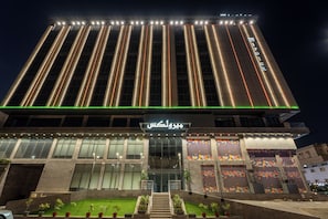 A modern building with vertical lighting accents and a prominent entrance with glass doors. - Mirolex Hotel (jeddah)