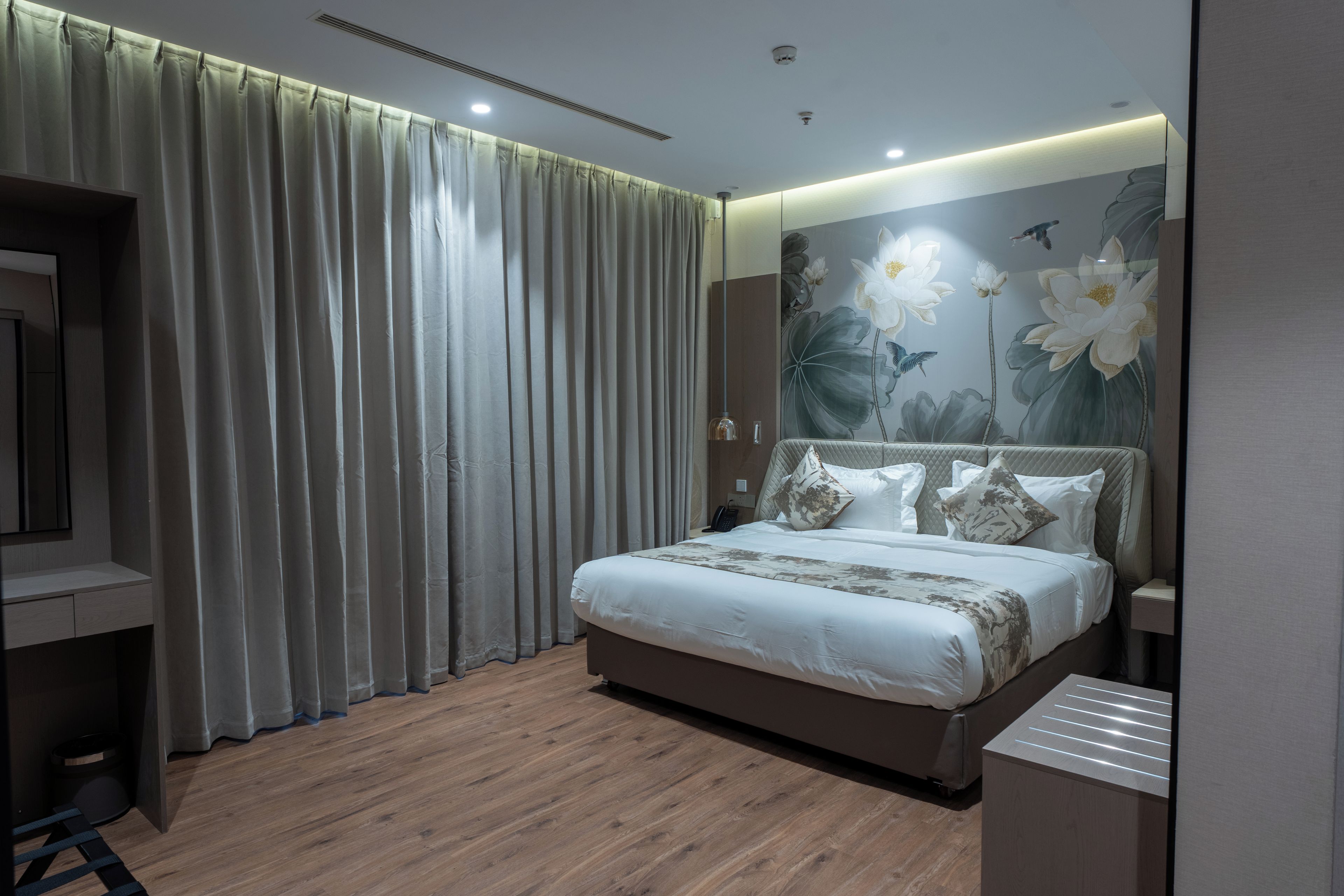 Ein modernes Schlafzimmer mit einem großen Bett, Holzböden und einer Wandmalerei mit floralem Muster.