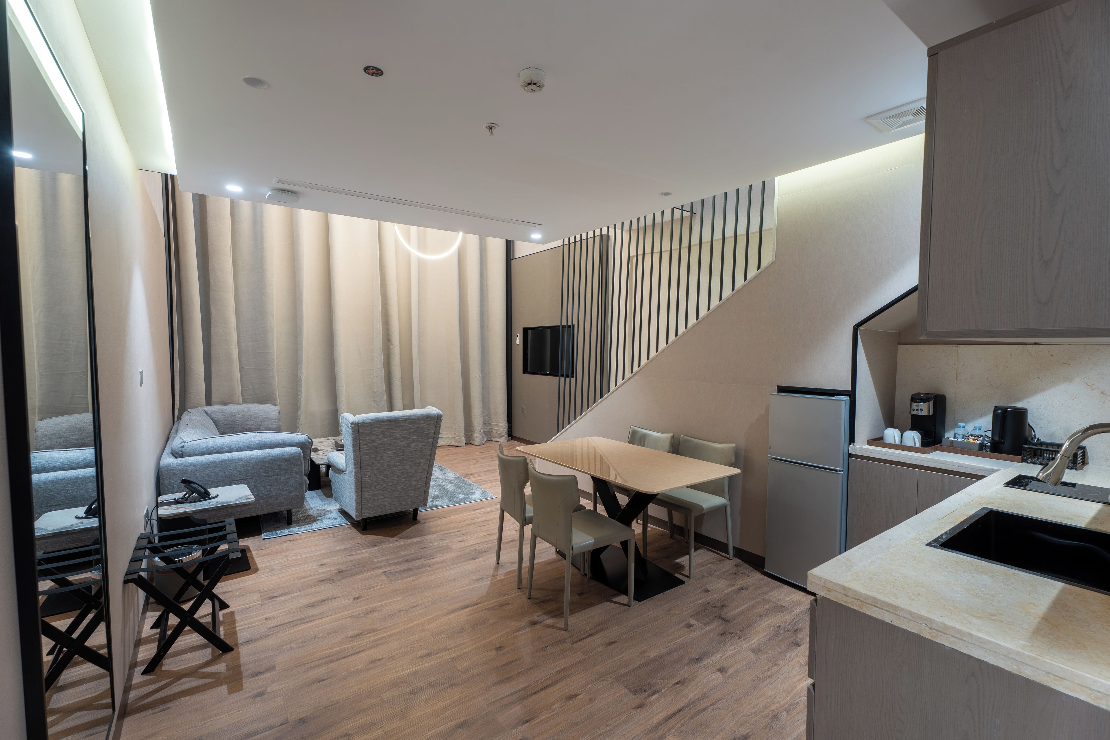 A modern interior with a dining area, kitchen, and seating space.