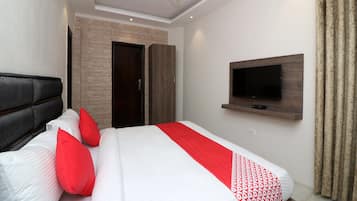 A modern bedroom with a bed, a television mounted on the wall, and a ceiling fan.