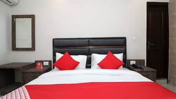 A hotel room with a bed, two nightstands, a telephone, and a mirror on the wall.