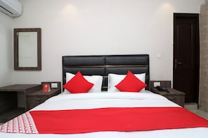 A hotel room with a bed, two nightstands, a telephone, and a mirror on the wall. - Hotel O Madhurapuri (Calicut)
