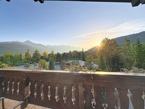 Ein Balkon mit Blick auf ein Tal, Berge und einen Fluss.