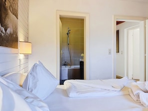 Quarto de hotel com cama, chuveiro e banheiro.
