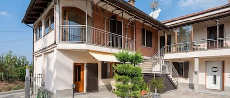 A two-story house with a balcony, a staircase, and a satellite dish.