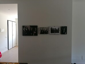 Un corridoio con una porta e una serie di fotografie in bianco e nero appese al muro.